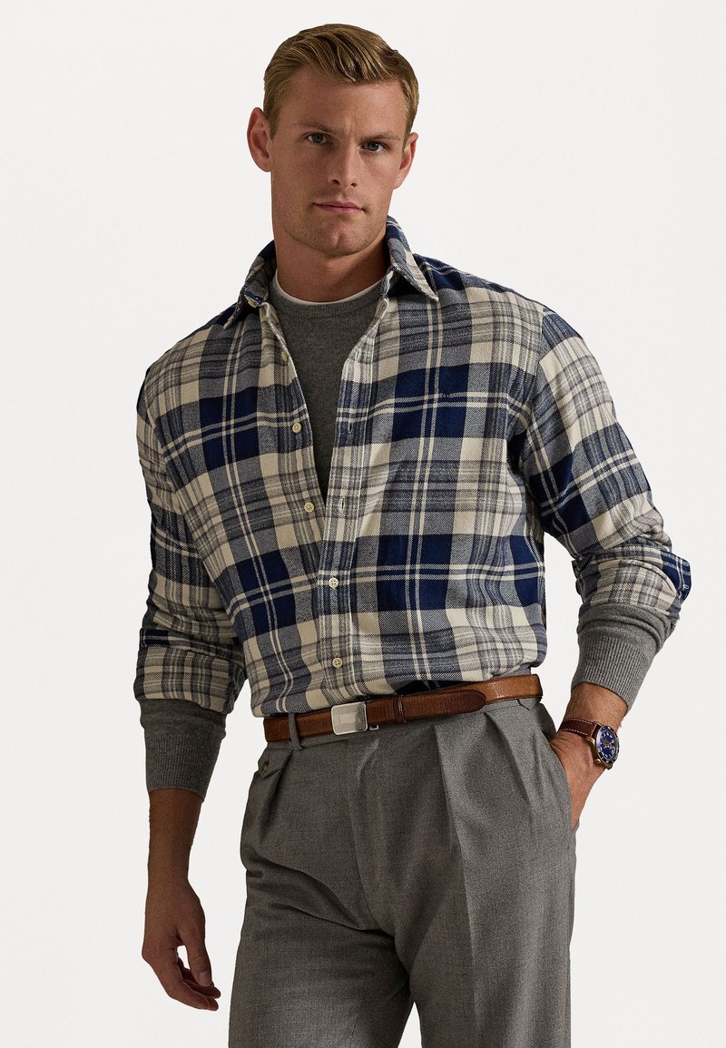 Flanellen overhemd in marineblauw en crèmekleurig ruitpatroon, met een button-down kraag en grijze gebreide accenten bij de manchetten. Gecombineerd met grijze broeken.