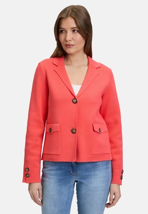 Blazer corail au fit ajusté, avec un devant à boutons, deux poches avant et des boutons décoratifs aux manches. Fabriqué à partir d'un tissu texturé et structuré.
