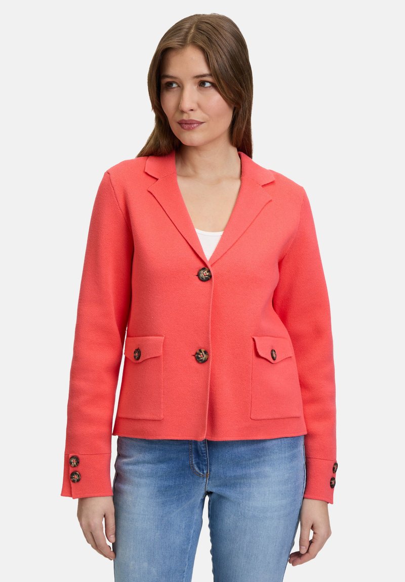 Blazer corail au fit ajusté, avec un devant à boutons, deux poches avant et des boutons décoratifs aux manches. Fabriqué à partir d'un tissu texturé et structuré.