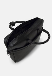 Malette en cuir noir avec une finition texturée, fermeture éclair, doubles poignées supérieures et un intérieur spacieux sans compartiments visibles.