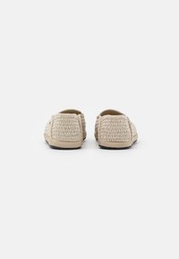 Scarpe slip-on beige in tessuto intrecciato con tomaia testurizzata, talloni arrotondati e suole in gomma flessibili. Progettate per comfort e facilità d'uso.
