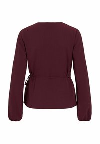 Burgunderfarbene Bluse mit langen Ärmeln und rundem Ausschnitt, tailliertem Bindegürtel und Ballonärmeln. Strukturierter Stoff mit subtilen Musterdetails.