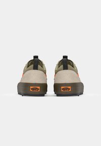 Calzado con una parte superior en beige, acentos en verde oliva y un tabique en negro. Incluye un logotipo naranja de "Off the Wall" en el talón.