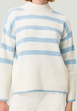 Pull en tricot léger de couleur crème avec des rayures horizontales bleues. Il présente un col montant et des poignets côtelés pour un détail texturé.