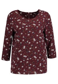 Top bordeaux con maniche tre quarti, stampa floreale con fiori bianchi e blu, tessuto morbido, scollatura rotonda con zip sul retro.