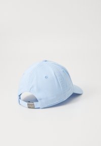 Lyseblå baseballcaps med buet skygge, justerbar stropp bak og subtile sømdetaljer. Glatt bomullsmateriale.