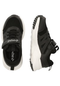 Scarpe da ginnastica nere in rete con suole in gomma bianca. Le caratteristiche includono una cinghia in Velcro, lacci neri e motivi testurizzati sulla suola.