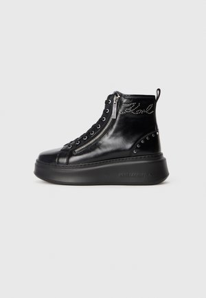 Black leather high-top sneaker boot with side zipper, lace-up front, studded detailing, and a thick platform sole.