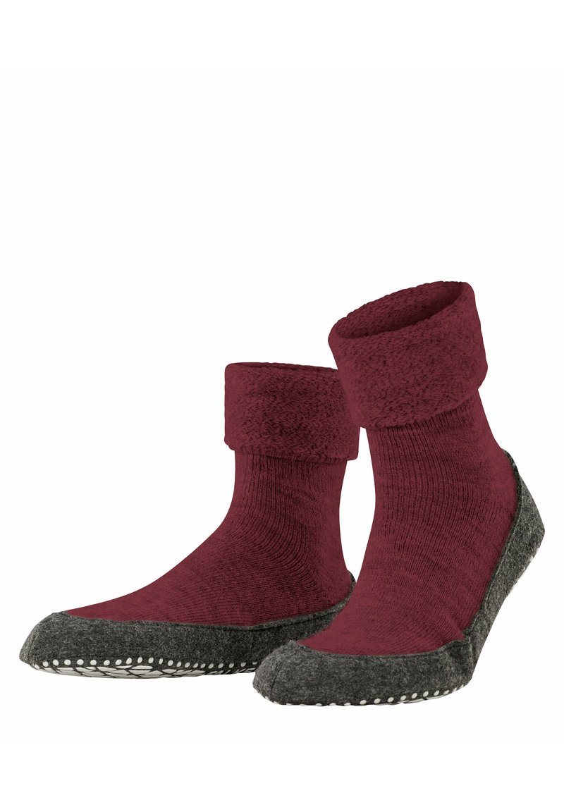 Czerwone wełniane skarpetki z miękkim, podwiniętym mankietem; szara teksturowana podeszwa z białym przeszyciem wzdłuż krawędzi dla lepszej przyczepności i trwałości.