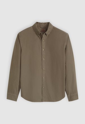 Chemise à manches longues marron avec un col boutonné, des boutons sur le devant et un ourlet légèrement incurvé.