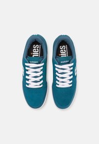 Teal suede sneakers with white laces and perforated toe region. Etnies branding on the side and insoles. Rubber sole with a textured design.