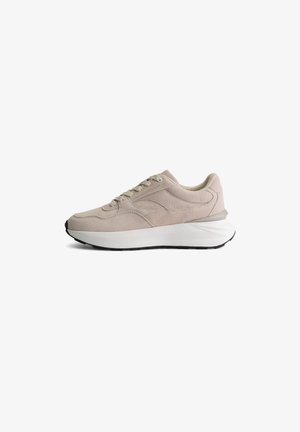 Beige suède sportschoen met een witte gestructureerde tussenzool en een zwarte rubberen buitenzool. Kenmerkt zich door een vetersluiting en een ronde neus.