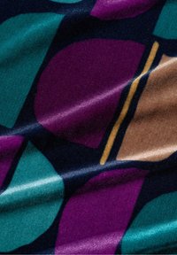 Bunt gemustertes Gewebe mit großen, überlappten Formen in Türkis, Lila und Braun sowie einer glänzenden Textur. Feine, kontrastierende goldene Linien heben das Design hervor.