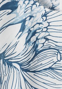 Tissu bleu et blanc avec un motif floral abstrait comprenant de grandes pétales et des formes regroupées dans diverses nuances de bleu.