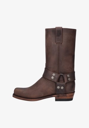 Bruine leren western laars tot halverwege de kuit met harnasriem en zilveren studs, houten hak en een treklus aan de bovenkant.