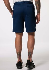 Námořnické sportovní šortky s elastickým pasem a boční kapsou, vyrobené z měkké a hladké tkaniny. Mají zakončený spodní lem a minimální švy.