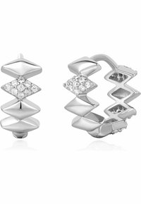 Silverhänge i form av hoops med ett sicksackmönster och diamantliknande detaljer. Ytan är polerad och reflekterar ljuset, vilket förstärker de geometriska formerna.