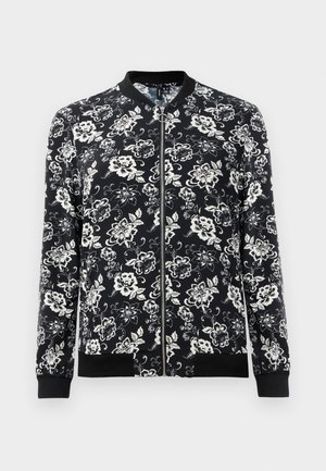 Veste bomber florale noire et blanche, dotée d'une fermeture éclair à l'avant, de poignets et d'un ourlet côtelés, avec un motif floral dense sur l'ensemble.