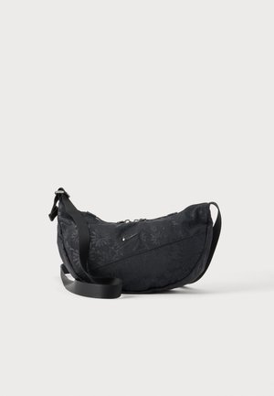 Sac d'épaule noir en forme de croissant avec un motif floral discret, une bandoulière réglable et un petit logo Nike argenté à l'avant.