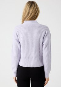 Jersey corto de lavanda con textura acanalada, mangas largas y cuello. Material suave y diseño sencillo sin adornos.