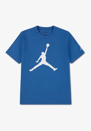 T-shirt bleu avec une grande silhouette blanche d’un joueur de basketball en train de sauter et tenant un ballon au centre devant.
