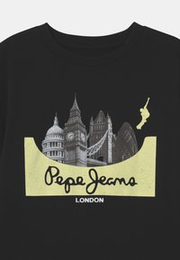 Černé tričko s grafikou londýnských památek v šedé barvě, ohraničené žlutou, s nápisem "Pepe Jeans LONDON" na spodní části.
