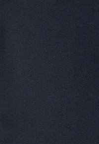 Texture de tissu tissé gris foncé avec un petit motif carré serré et des variations subtiles de couleur sur toute la surface.