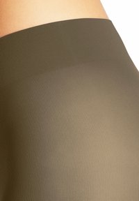 Leggings a coste verde oliva con vita alta, texture liscia e design aderente, adatti per abbigliamento casual o sportivo.