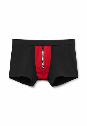 Černé boxerky s červeným předním panelem, na kterém je vertikální černý zip s nápisem "OTEVŘETE OPAKOVANĚ" v bílém textu.