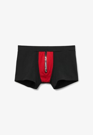 Zwarte boxershorts met een rood voorpaneel met een verticale zwarte ritssluiting, met de tekst "OPEN VOORZICHTIG" in witte letters.