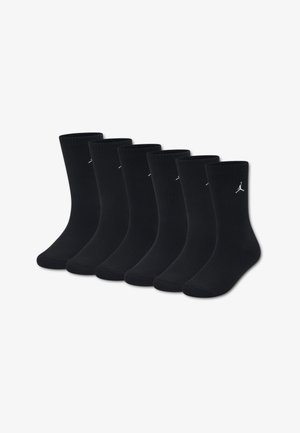 Kuus paari musta puuvillast madala säärega sokid, millel on sooniline muster ja väike valge logo pealmisel küljel. Tavaline sokikuju.