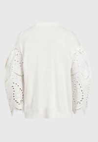 Biały sweter z gładkim tyłem i obszerne rękawy z koronką z oczkami, charakteryzujące się kwiatowymi i geometrycznymi wzorami wycięć.