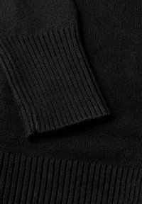 Svart stickad tröja med detaljer som har ribbat mudd. Texturen är mjuk, med släta och fluffiga fibrer synliga genom hela plagget.