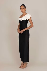 Black evening gown with a fitted bodice, one-shoulder design, and ruffled white accent. Smooth fabric and floor-length silhouette.