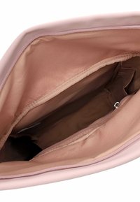 Rožinė rankinė viduje su lygiu audiniu, turinti užtrauktuką kišenėje ir pagrindinę dalį, demonstruojanti minkštą, matinį tekstūrą.