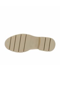 Sole di una scarpa, in gomma beige, caratterizzata da scanalature orizzontali e creste per una maggiore aderenza. Design della punta arrotondata, con marchi del brand vicino al tallone.