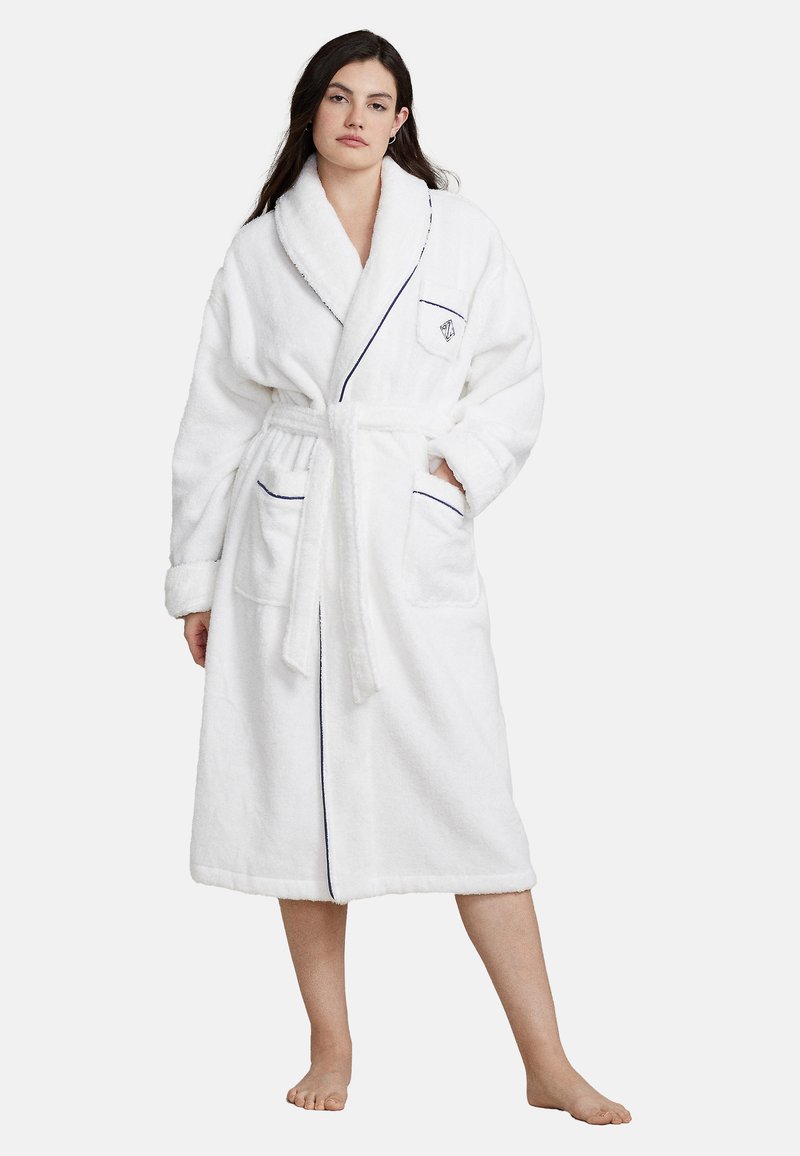 White terry robe with a shawl collar, contrasting navy piping, belt, and two front pockets. Soft texture and knee-length design.