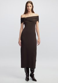 Braunes, schulterfreies, geripptes Kleid mit gerafften Details und einem dekorativen Knopf. Langer, taillierter Schnitt, kombiniert mit kniehohen Stiefeln.