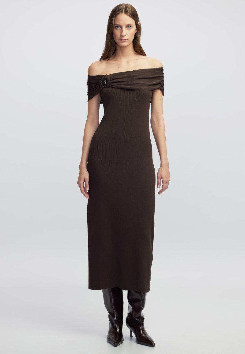 Braunes, schulterfreies, geripptes Kleid mit gerafften Details und einem dekorativen Knopf. Langer, taillierter Schnitt, kombiniert mit kniehohen Stiefeln.
