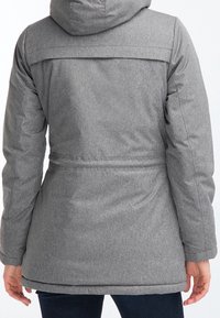 Harmaa huppuparka, jossa on tekstuurinen kangas, vyötäröltä kiristetty, suora leikkaus ja pitkät hihat, näkyy takaa.