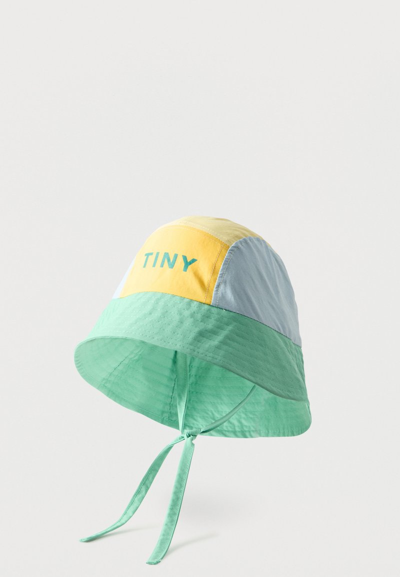 Chapeau seau à blocs de couleurs avec des panneaux jaune, bleu clair et vert menthe, texte "TINY" sur le panneau jaune, et des lanières menthe attachées en nœud sous le menton.