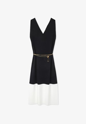 Ärmelloses Kleid mit tiefem V-Ausschnitt, schwarzem Oberteil und weißem Rock. Verfügt über einen goldenen Kettengürtel mit einem Schlüsselanhänger, glatte Stofftextur.