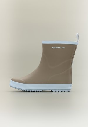 Hnědá gumová dešťová bota s bílou podrážkou a texturovaným protiskluzovým vzorem, s bílým pruhem nahoře a logem "Tretorn 1891" po straně.