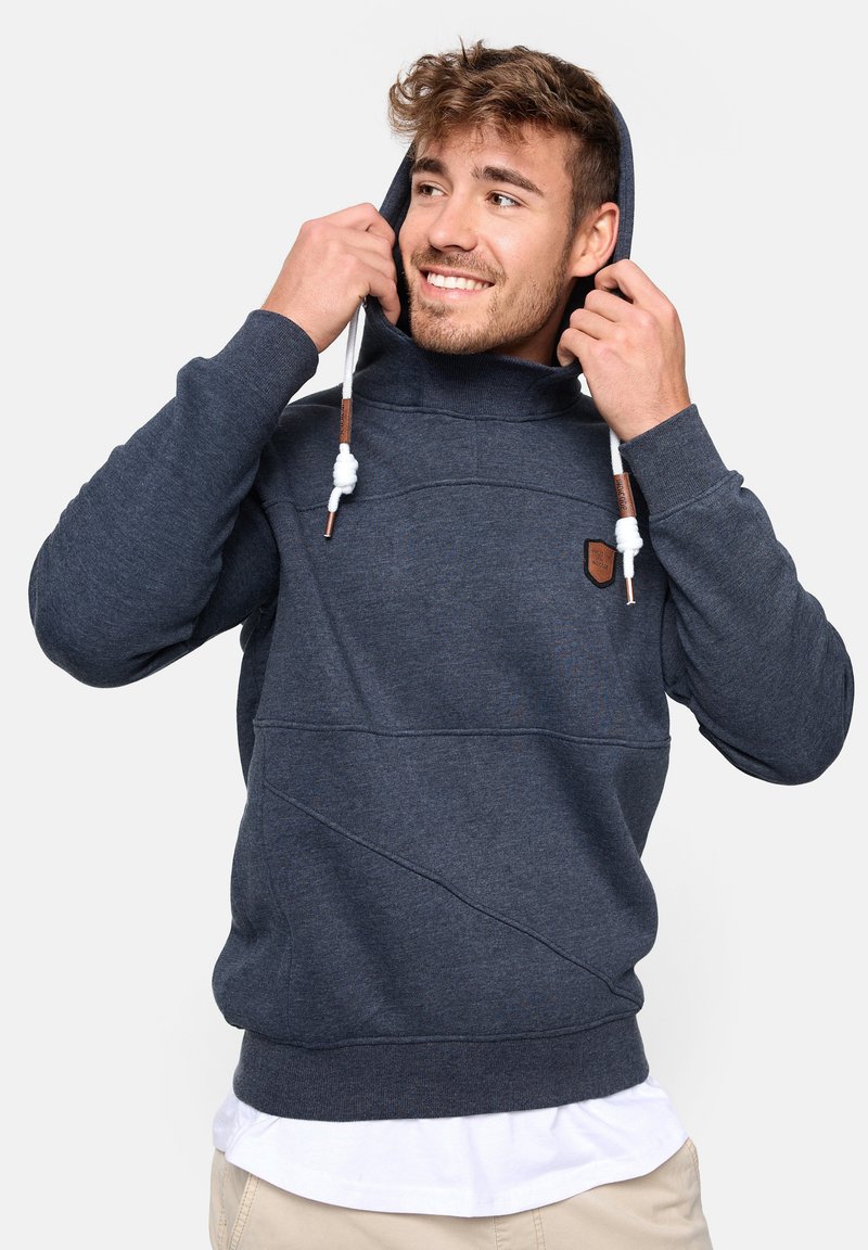 Sudadera de color azul oscuro con un alto cuello, bolsillo tipo canguro y cordones blancos. Presenta una tela texturizada y un pequeño logo de cuero en el pecho.