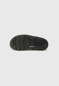 Rubber shoe sole with a textured black finish, featuring deep grooves and patterns for traction. Accented with a maroon upper section.