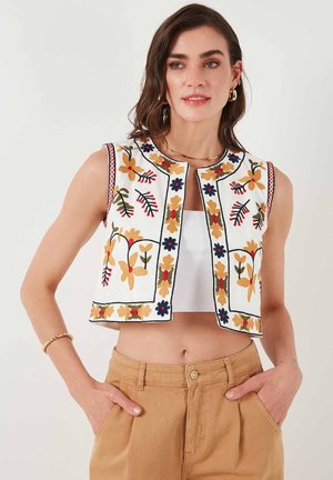 Geborduurde vest in witte stof met bloemenpatronen in oranje, blauw en groen, met een ronde halslijn en een cropped ontwerp.