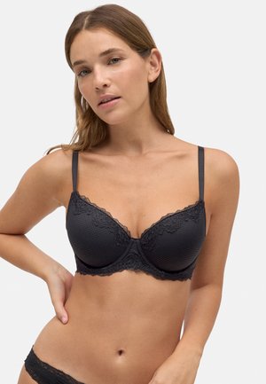 Sujetador negro con encaje, fabricado con un tejido texturizado, soporte con aros y tirantes ajustables, que cuenta con un escote pronunciado y copas sin costuras.