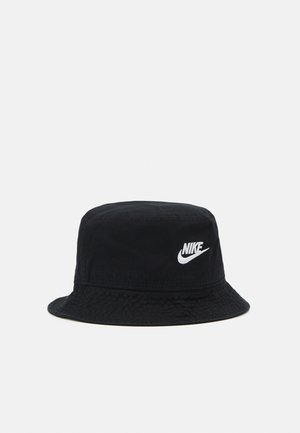 Gorro de cubo negro hecho de tela texturizada, con un logo de Nike blanco en la parte delantera. Ala ancha que se inclina hacia abajo. Diseño simple y funcional.