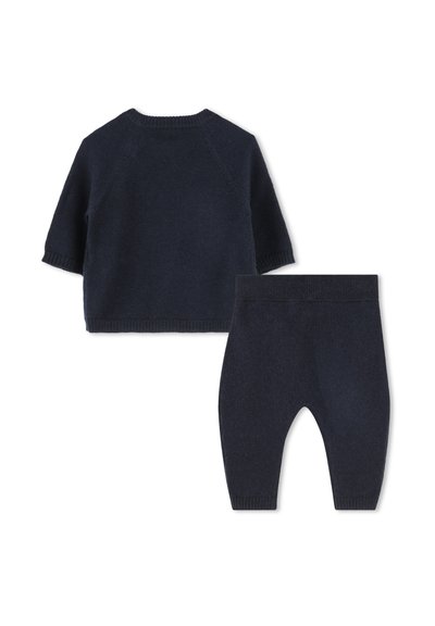 Marine gebreide babytrui met korte mouwen en bijpassende broek. Zachte textuur, geribbelde manchetten en tailleband; beide items zijn naadloos en comfortabel.