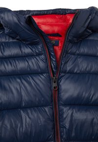 Gilet imbottito blu navy con cappuccio, caratterizzato da una fodera rossa, chiusura frontale con cerniera e texture trapuntata. Realizzato in materiale sintetico liscia.